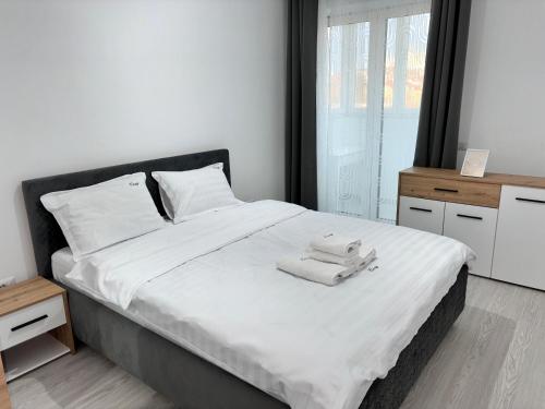 a bedroom with a large bed with two towels on it at Cozy Unique Penthouses with Terrace and Suceava Magic View in Suceava