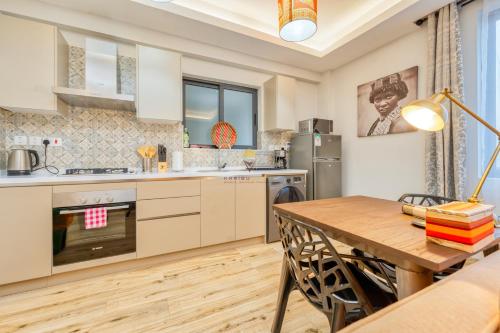 a kitchen with a wooden table and a dining room at Elite Residence 7 Star Luxe Condo with Gym and Pool next to JW Marriott, Westlands Airport Shuttle, Luggage Storage available in Nairobi