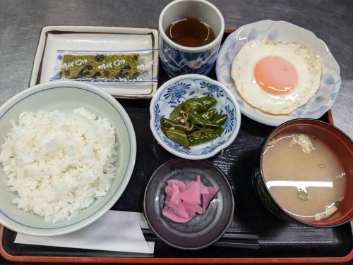 a tray with rice and bowls of food on it at ビジネスホテルみやこ in Higashi-osaka