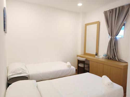 a hotel room with two beds and a mirror at Shoreline Guesthouse 海岸线客栈 in Semporna