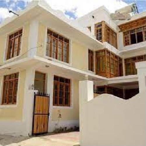 a large white house with a large building at Hotel DE Suzain-Leh in Leh