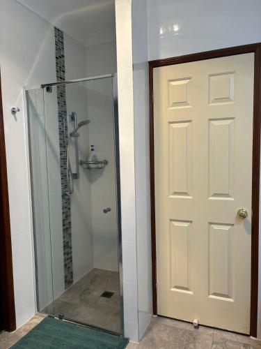 a shower with a glass door in a bathroom at Garden Retreat House Sunnybank Hills - Super quite and Peace in Brisbane