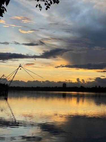 a sunset over a large body of water at AshtamudiVillas in Kollam