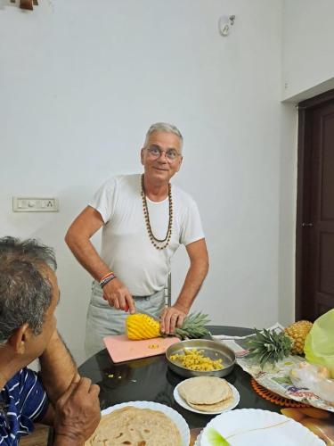 an older woman cutting corn on a cutting board at Marari Bethsaida Homestay in Shertallai