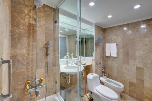 a bathroom with a toilet and a sink and a shower at Pearl Continental Hotel, Rawalpindi in Rawalpindi