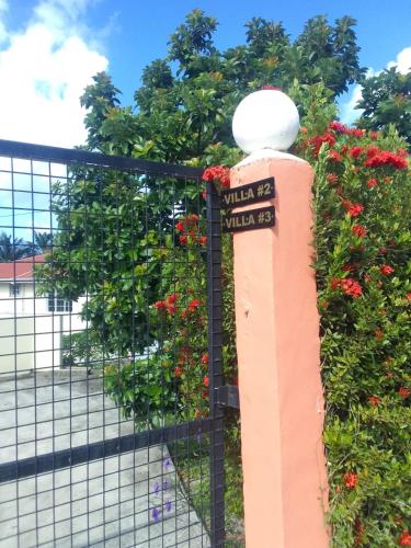 a fence with flowers and a sign on it at Chalet Belizomi Tropical Villas No #2 in Rodney Bay Village