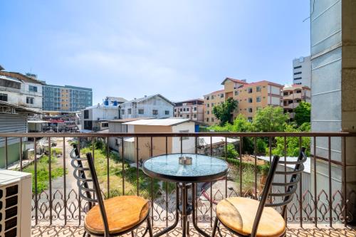 a balcony with a table and two chairs at Abunawas Merry Inn at Walking Street in Pattaya South