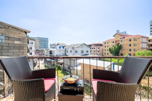 a balcony with two chairs and a grill at Abunawas Merry Inn at Walking Street in Pattaya South