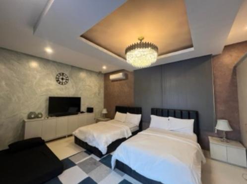 une chambre d'hôtel avec deux lits et une télévision dans l'établissement Highland Villas Royale Corp, à Alfonso