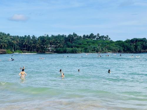 a group of people in the water at the beach at Villa Bellissimo - Hiriketiya in Dickwella