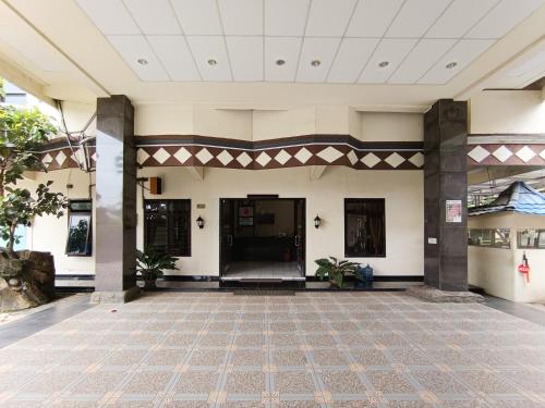 an empty lobby of a building with a tile floor at Gita Puri RedPartner Blitar in Blitar