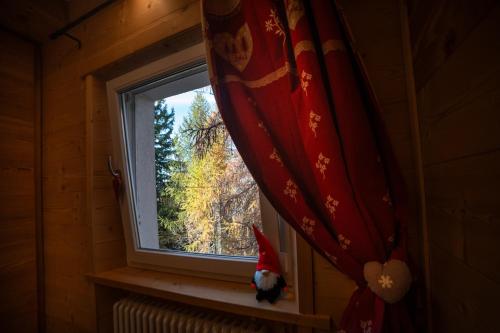 a cat in a santa hat looking out of a window at Angolo del Bosco in Pila