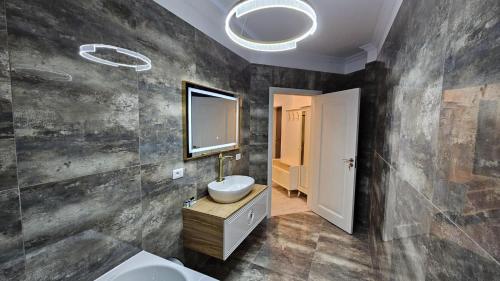 a bathroom with a sink and a mirror at Book your Luxury Cozy Apartment in City Center Suceava in Suceava