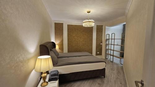 a bedroom with a bed and a chandelier at Book your Luxury Cozy Apartment in City Center Suceava in Suceava
