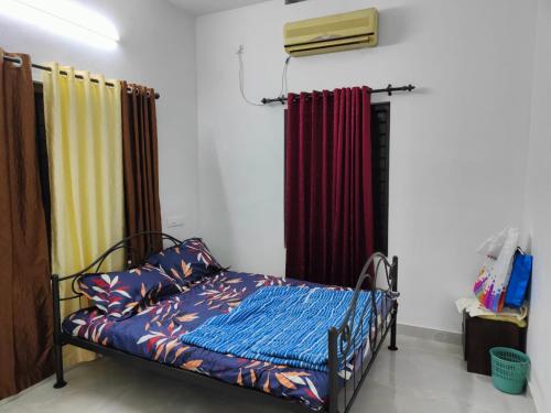 a bedroom with a bed in a room with curtains at Sole shell Chalets in Kappil