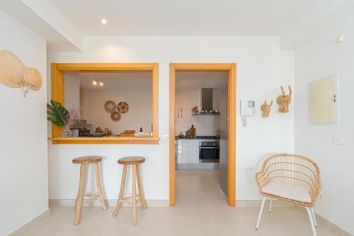 a kitchen with two bar stools and a counter at Hermanas de Pulpi in San Juan de los Terreros