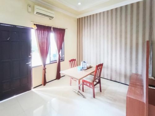 a dining room with a table and two chairs at Gita Puri RedPartner Blitar in Blitar