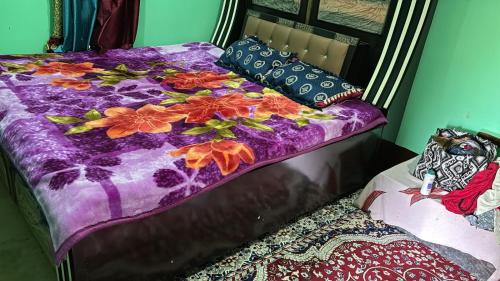 a bed with a purple blanket and pillows on it at VILLAGE SUKOON HOME STAy in Rānīkhet