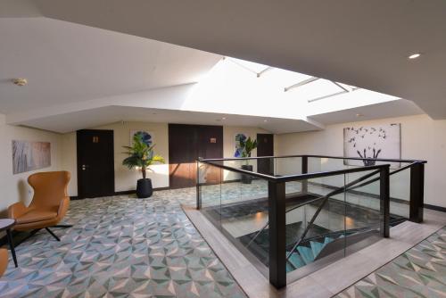 a lobby with a glass staircase in a building at Waxwing Hotel in Hatay