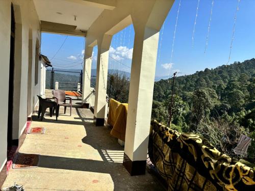 a balcony of a house with a view of trees at VILLAGE SUKOON HOME STAy in Rānīkhet