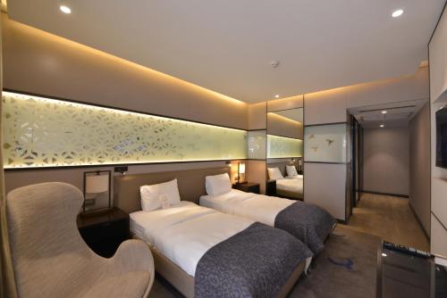 a hotel room with two beds and a mirror at Waxwing Hotel in Hatay
