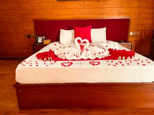 a bed with red and white sheets and a heart blanket at New Saniro Lagoon Deck in Katunayaka