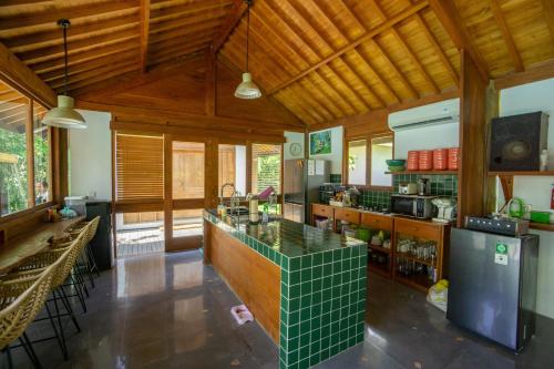 a large kitchen with wooden ceilings and a green counter top at Pool & Jungle View Family Room in Kaba-Kaba in Tabanan