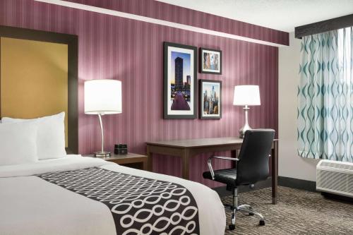 a hotel room with a bed and a desk and a chair at La Quinta by Wyndham Newark - Elkton in Elkton