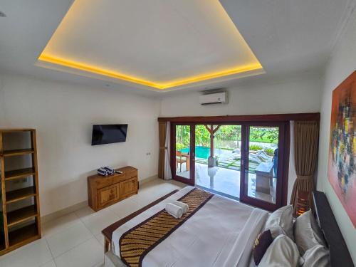 a bedroom with a large bed and a large window at Uma Jala Villa Ubud in Ubud