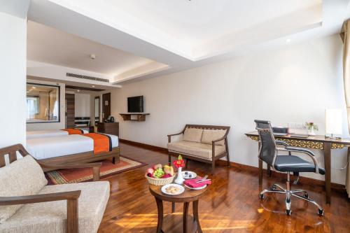 a hotel room with a bed and a living room at Ramada by Wyndham Kathmandu Dhumbarahi in Kathmandu