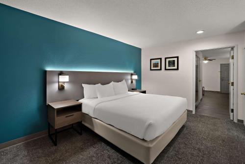 a bedroom with a large white bed and a blue wall at Comfort Inn & Suites Santee I-95 in Santee