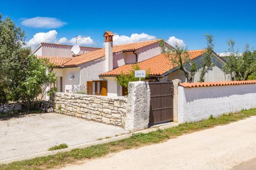 a house with a stone fence and a gate at Villa Lavinija in Kavran