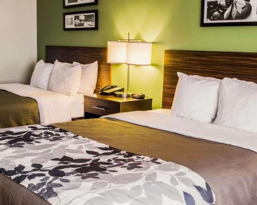a hotel room with two beds and a telephone at Sleep Inn & Suites Virginia Horse Center in Lexington