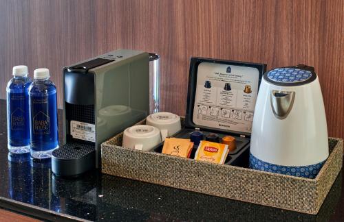 a counter top with a coffee maker and bottles of water at Baba House Melaka in Melaka