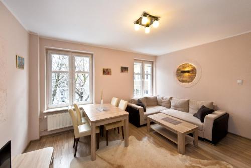 グダニスクにあるGdańskie Apartamenty - Apartament Szeroka with 2 roomsのソファとテーブルのあるリビングルーム