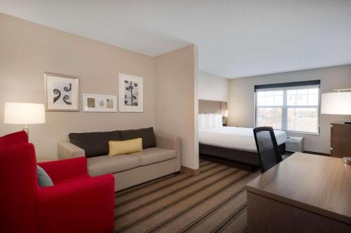アルバートビルにあるCountry Inn & Suites by Radisson Albertville near Outlet Mallのソファとベッドのあるリビングルーム