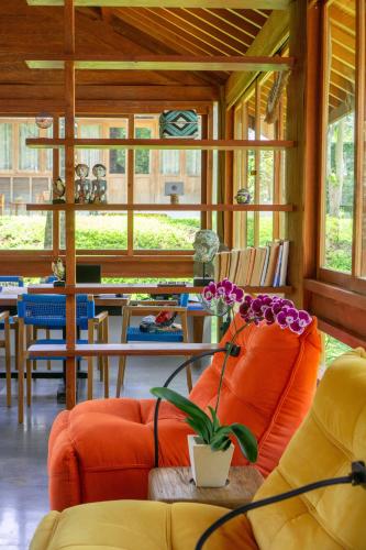 a living room with an orange couch and a plant at Pool & Jungle View Family Room in Kaba-Kaba in Tabanan