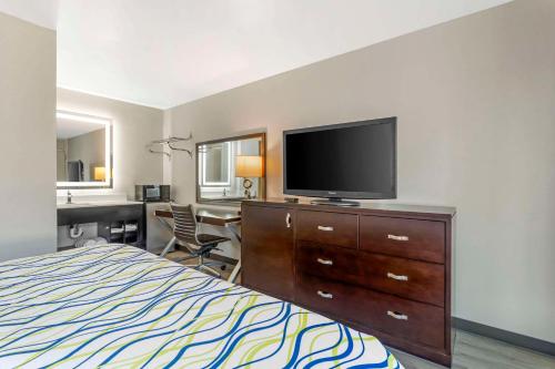 a hotel room with a bed and a flat screen tv at Rodeway Inn in Orange Park
