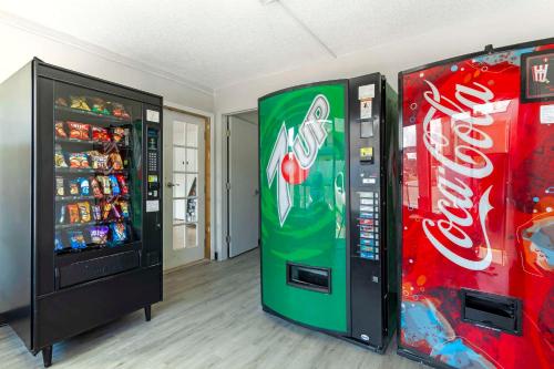 two cocacola machines are next to a soda machine at Rodeway Inn in Orange Park