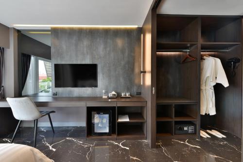a bedroom with a desk and a tv in a room at Victora Hostel in Bangkok