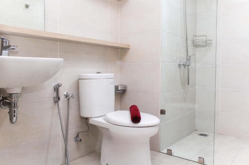 a bathroom with a toilet and a sink and a shower at Modern and Spacious Studio Apartment at Mustika Golf Residence By Travelio in Cikarang