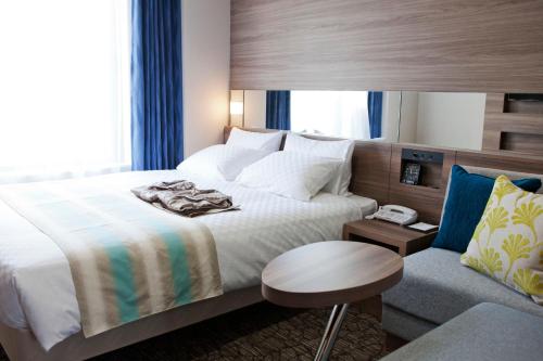a hotel room with a bed and a chair at Almont Hotel Naha Kenchomae in Naha