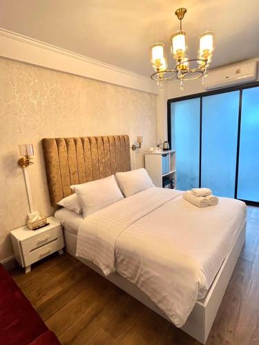 a bedroom with a large white bed and a chandelier at Sweetloft Hotel Don Muang in Bangkok
