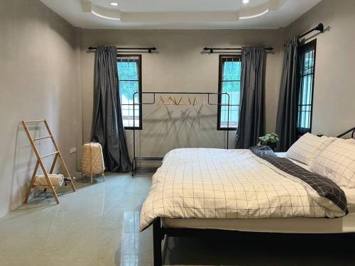 a bedroom with a bed and two windows at Charming Getaway in Koh Chang in Ko Chang