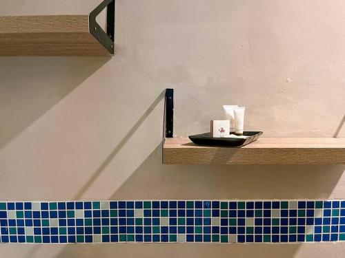 a shelf with a plate and cups on a wall at Charming Getaway in Koh Chang in Ko Chang