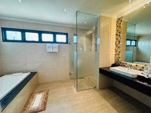 a bathroom with a tub and a sink and a shower at Mintra Hotel in Vientiane