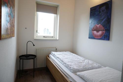 a small bedroom with a bed and a window at Kustverhuur, Vakantiepark Fort Soleil 43 in Breskens