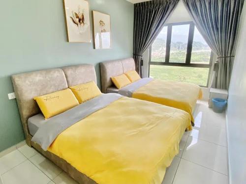 a bedroom with two beds with yellow and gray sheets at Decozy7.0 Ipoh Town Condo(12pax) in Ipoh