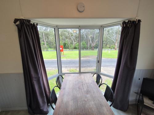 a table and chairs in a room with a large window at Eagle Point Caravan Park in Eagle Point