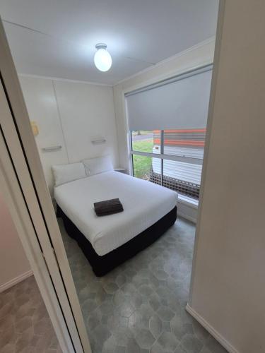 a bedroom with a bed and a large window at Eagle Point Caravan Park in Eagle Point